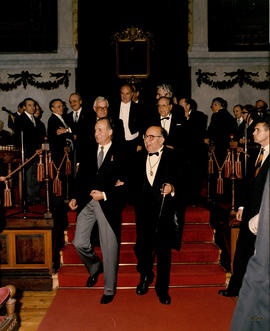 El rey Juan Carlos I y Fernando Lázaro Carreter, director, bajan las escaleras del estrado del Sa...