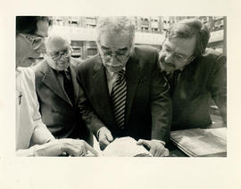 Gabriel García Márquez junto a Gregorio Salvador y Juan Luis Cebrián ojeando un libro de la Bibli...