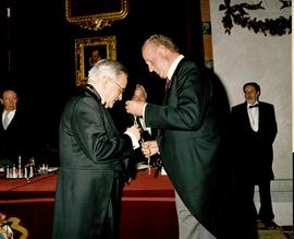 Juan Carlos I de España coloca la medalla de académico a Luis Ángel Rojo