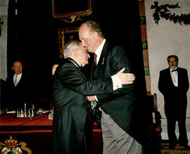 Juan Carlos I de España coloca la medalla de académico a Luis Ángel Rojo
